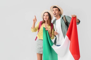 Açık arkaplanda İtalyan bayrağı taşıyan genç turistler