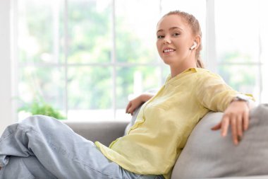 Evde müzik dinleyen havalı genç bir kadın.