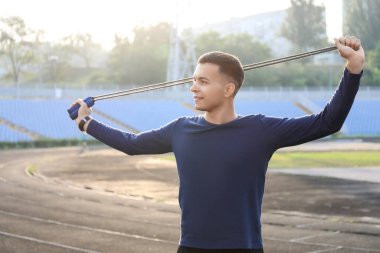 Stadyumda ip atlayan genç bir adam.