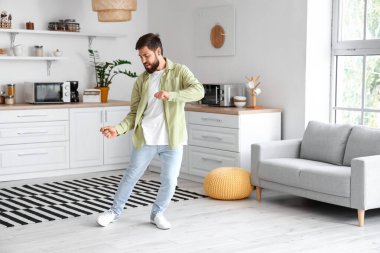 Mutfakta dans eden yakışıklı adam.