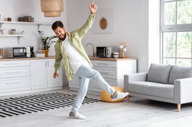 Mutfakta dans eden yakışıklı adam.