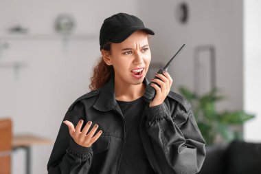 Ofisinde radyo vericisi olan kızgın Afro-Amerikalı kadın güvenlik görevlisi.