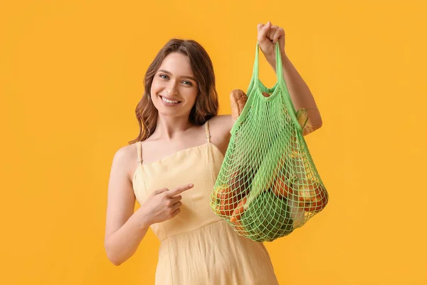 Giovane Donna Possesso Borsa Stringa Con Cibo Sfondo Giallo — Foto Stock