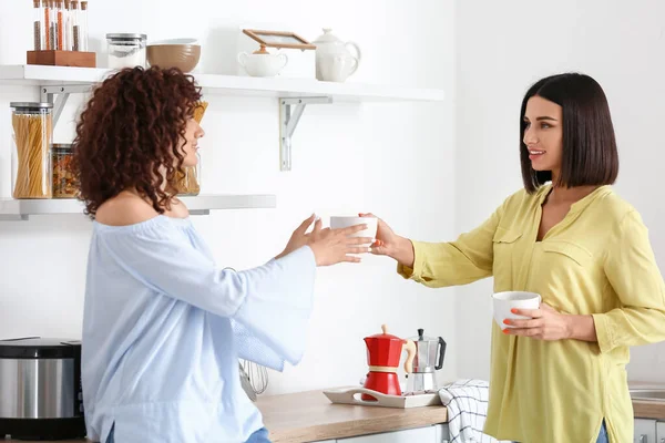 Young Woman Giving Cup Tea Her Sister Kitchen — Stock Photo, Image