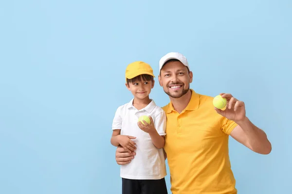 Kisfiú Edzője Teniszlabdákkal Kék Háttéren — Stock Fotó