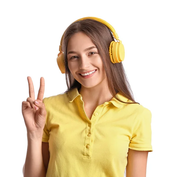 Cool Mladá Žena Poslouchá Hudbu Ukazuje Vítězství Gesto Bílém Pozadí — Stock fotografie