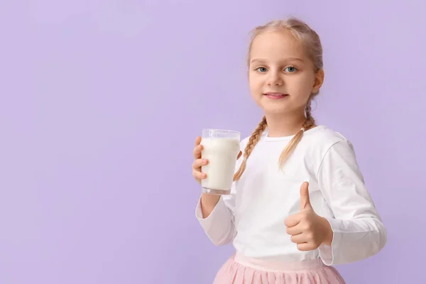 Cute Little Girl Szklanką Mleka Pokazując Kciuk Górę Tle Liliowym — Zdjęcie stockowe