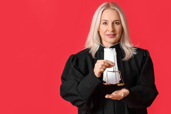 Зрелая Судья Халате Весами Правосудия Красном Фоне — стоковое фото