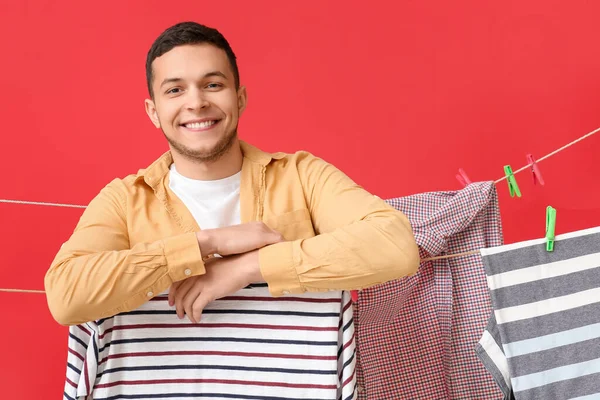 Young Man Hanging Laundry Clothespins Red Background — Stock Photo, Image