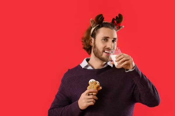 Handsome Man Deer Horns Gingerbread Cookies Drinking Milk Red Background — Stock Photo, Image
