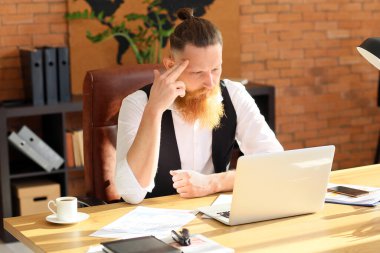 Ofiste çalışan yakışıklı sakallı iş adamı.