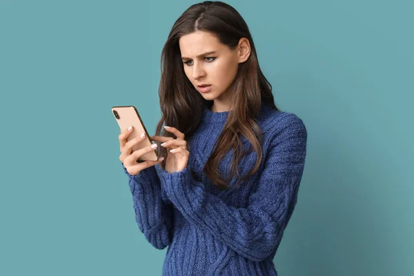 Nespokojená Mladá Žena Mobilním Telefonem Modrém Pozadí — Stock fotografie