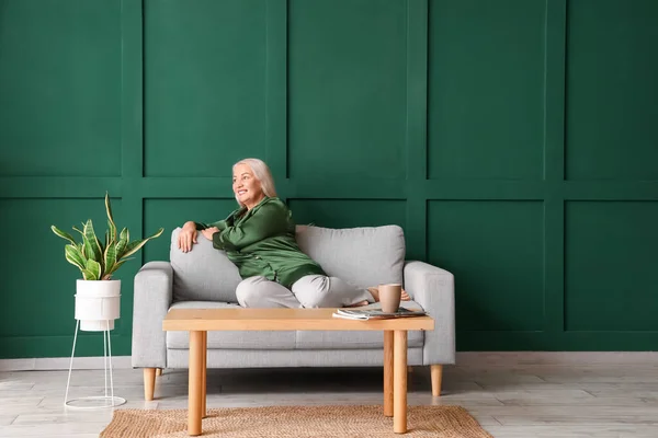 Yeşil Duvarın Yanındaki Koltukta Oturan Olgun Bir Kadın — Stok fotoğraf