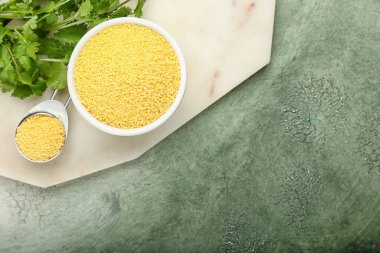 Arkaplanda maydanozlu çiğ kuskus ve kaşık.