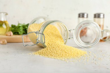 Işık arkaplan üzerinde ham kuskus olan kavanoz