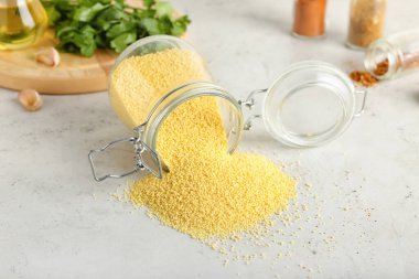 Işık arkaplan üzerinde ham kuskus olan kavanoz