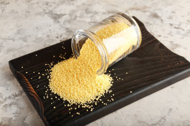 Grunge arka planında ham kuskus olan kavanoz