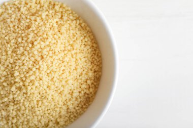 Beyaz arka planda bir kase ham kuskus, yakın plan.