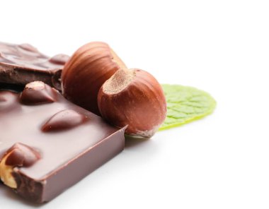 Beyaz arka planda fındıklı lezzetli çikolata parçaları, yakın plan.