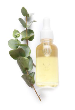 Beyaz arka planda bir şişe doğal okaliptüs yağı.