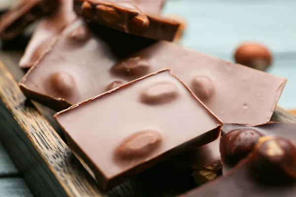 Pieces Tasty Chocolate Nuts Board Closeup — Stock Photo, Image