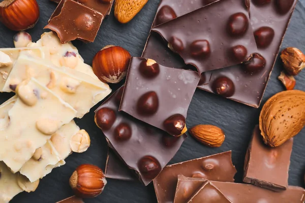 Pieces Tasty Chocolate Nuts Dark Background — Stock Photo, Image
