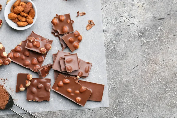 배경에 견과가 맛있는 초콜릿 조각들 — 스톡 사진