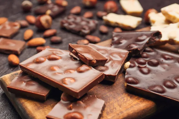 Board Pieces Tasty Chocolate Nuts Dark Background Closeup — Stock Photo, Image