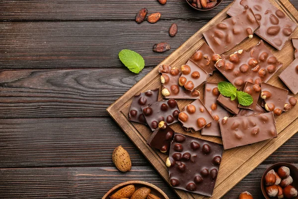 Tafel Mit Leckeren Schokoladenstücken Und Nüssen Auf Dem Tisch — Stockfoto