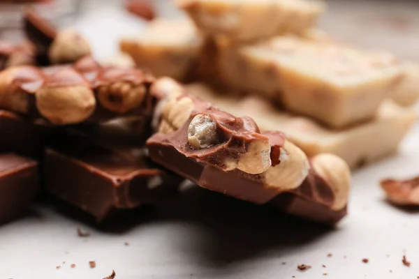 Pieces Tasty Chocolate Hazelnuts Table Closeup — Stock Photo, Image