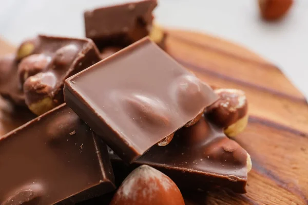Pieces Tasty Chocolate Hazelnuts Board Closeup — Stock Photo, Image