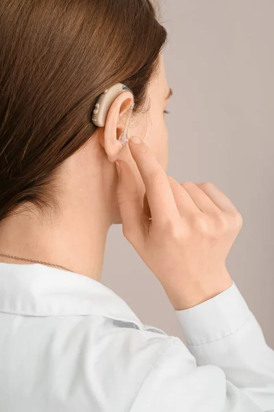 Mujer Joven Con Audífono Oído Sobre Fondo Gris Primer Plano — Foto de Stock