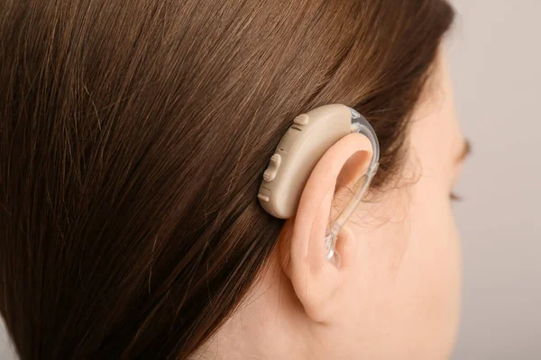 Young Woman Hearing Aid Her Ear Grey Background Closeup — Stock Photo, Image
