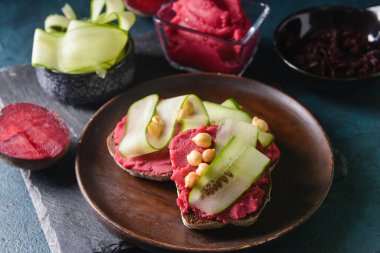 Koyu arkaplanda bir tabak ekmek ve lezzetli humus.