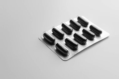 Gri arka planda etkinleştirilmiş karbon kapsülleri kabarcık paketi