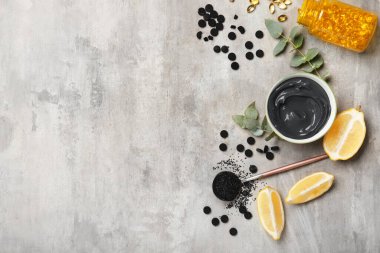 Grunge arka planında etkinleştirilmiş karbon yüz maskesi hazırlamak için malzemeler içeren bileşim