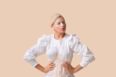 Yaratıcı makyajı ve parlak arka planda zarif küpeleri olan güzel genç bir kadın.