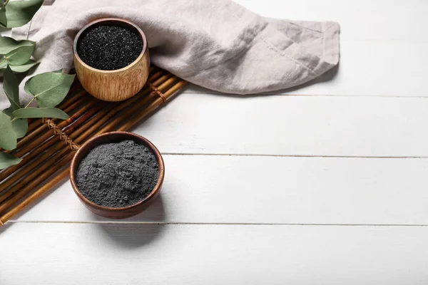 Hafif ahşap zemin üzerinde aktive edilmiş karbon tozu ve maske kaseleri, yakın plan