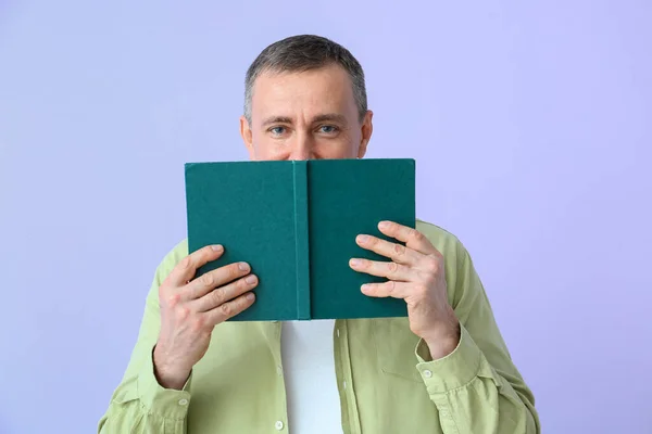 Volwassen Man Lezing Boek Lila Achtergrond — Stockfoto