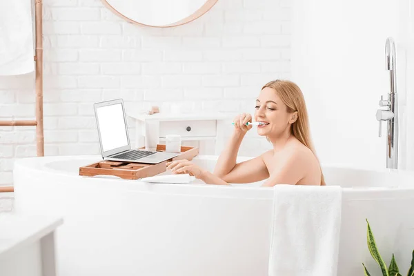 Bilgisayarlı Banyo Yapan Dişlerini Fırçalayan Güzel Olgun Bir Kadın — Stok fotoğraf