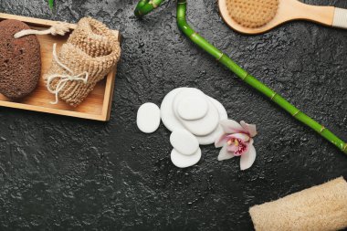 Banyo malzemeleri ve koyu arkaplanda taşlar olan spa kompozisyonu