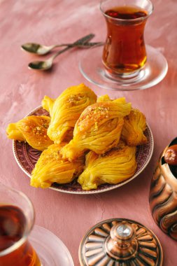 Renkli çay arkaplanlı lezzetli Türk baklavası