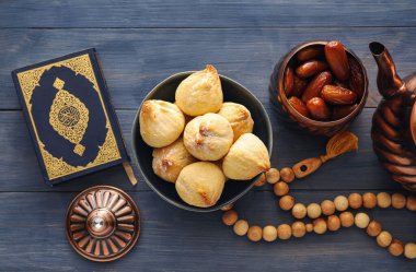 Kuran ve tahtadan arkaplanda tasbih ile lezzetli doğu tatlıları.