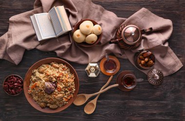 Ahşap zemin üzerinde Kur 'an olan geleneksel doğu yemekleri