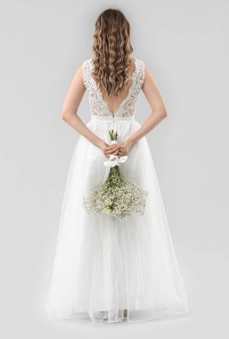 Açık arkaplanda çiçek demeti olan güzel gelin.