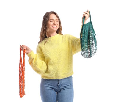 Beyaz arka planda ip torbaları olan genç bir kadın.