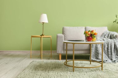 Gri kanepeli, masalı ve meyve sepetli oturma odasının içi.