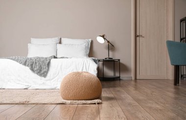 Modern yatak odasının içindeki bej pouf