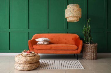 Kırmızı kanepe ve rattan puflarla oturma odasının içinde.