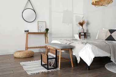 Şık yatak odasında yumuşak koltuklu ahşap bir bank.